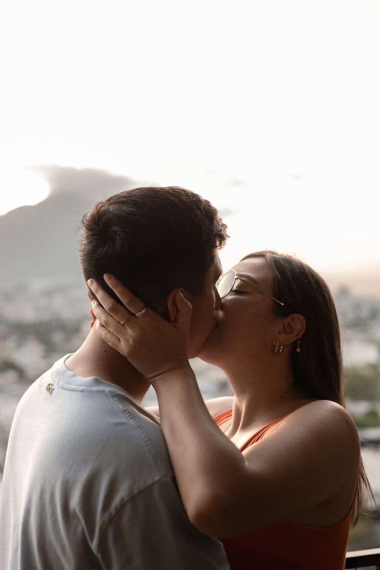 A couple shares a tender kiss during a sunset in Monterrey, Mexico, symbolizing love and intimacy.